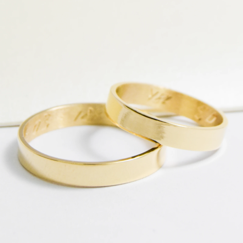 Alianzas de casamiento de oro 18K amarillo modelo Cinta sobre fondo blanco
