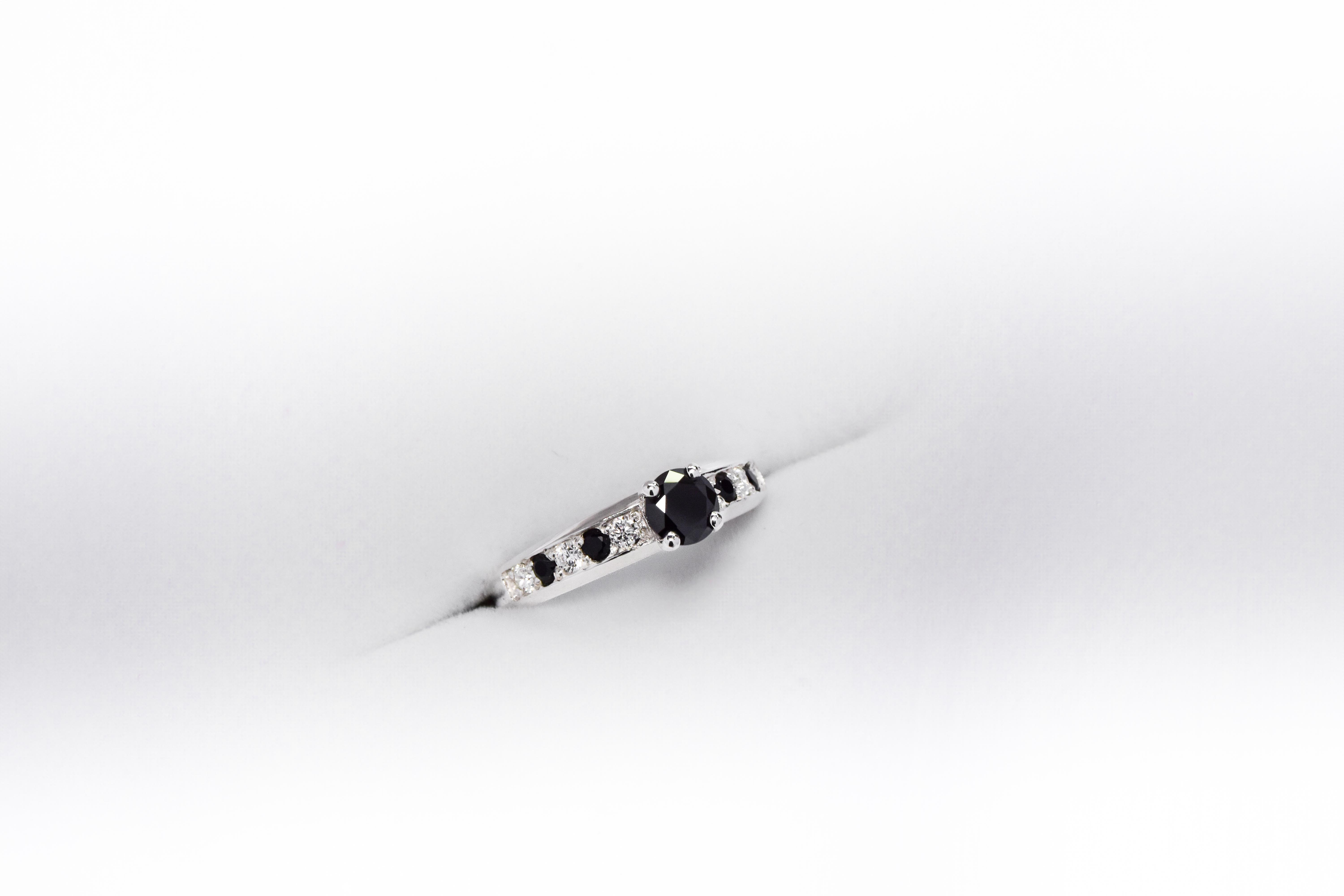 Anillo de compromiso de plata 925k con gemas blancas y negras sobre fondo blanco