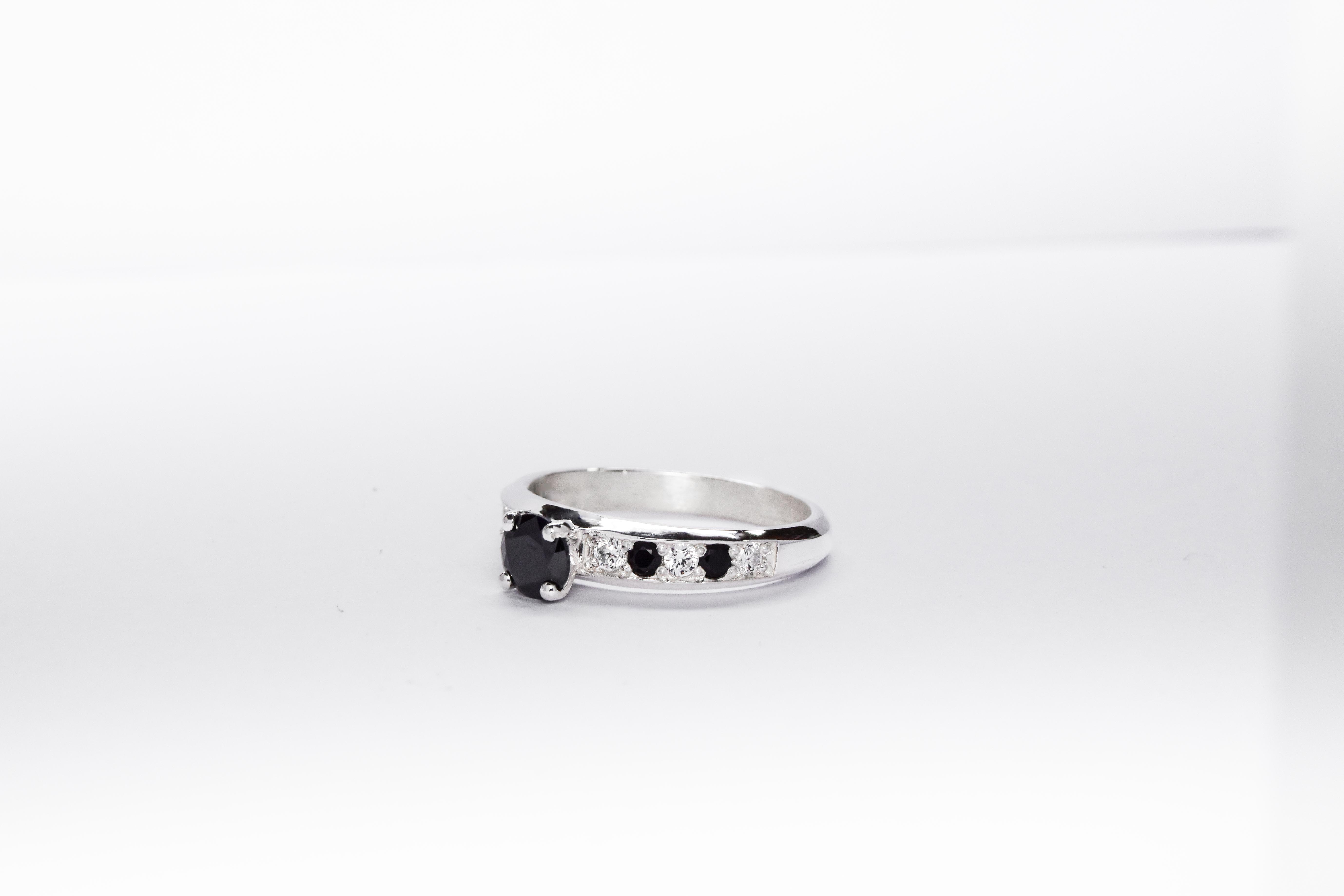 Anillo de compromiso de plata 925k con gemas blancas y negras sobre fondo blanco