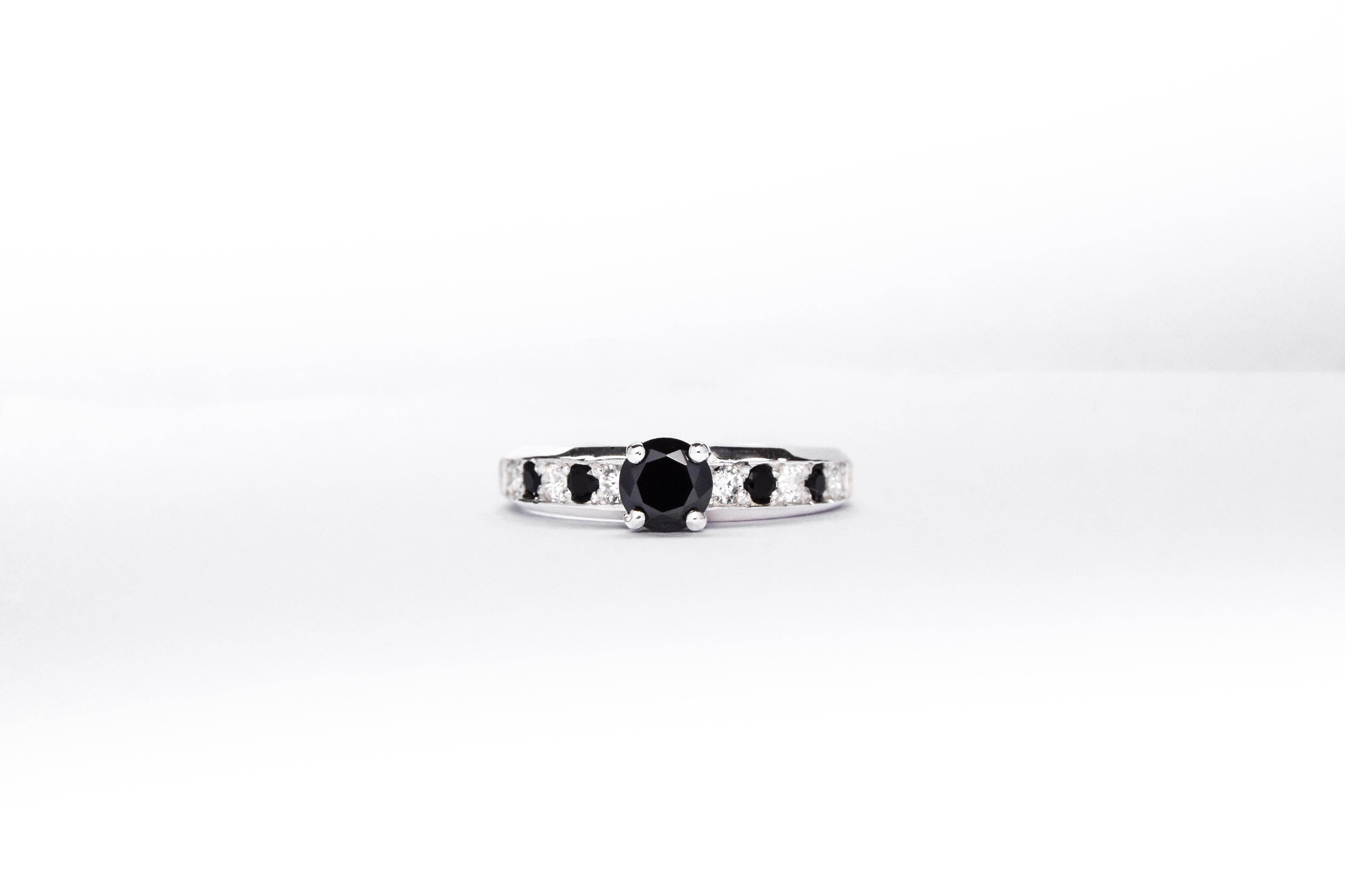 Anillo de compromiso de plata 925k con gemas blancas y negras sobre fondo blanco
