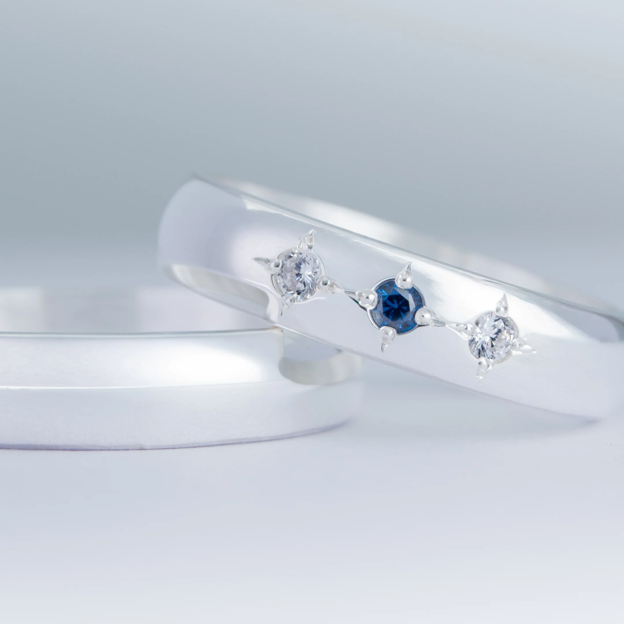 Par de alianzas de casamiento en plata 950 con zafiros azules y diamantes, modelo Aster, fabricadas artesanalmente en Buenos Aires — Haikmaro Joyería
