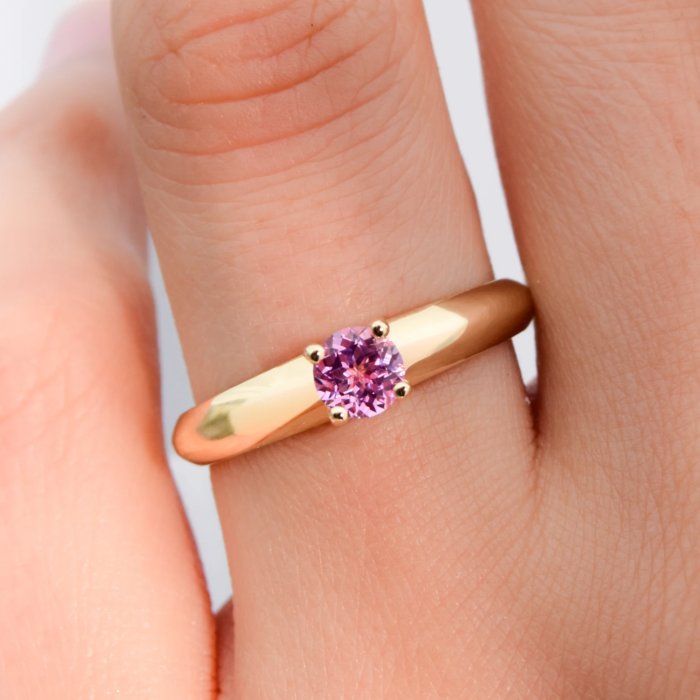 Anillo de compromiso de oro 18K amarillo modelo Princess 5 con zafiro Lab Grown Rosa sobre la mano