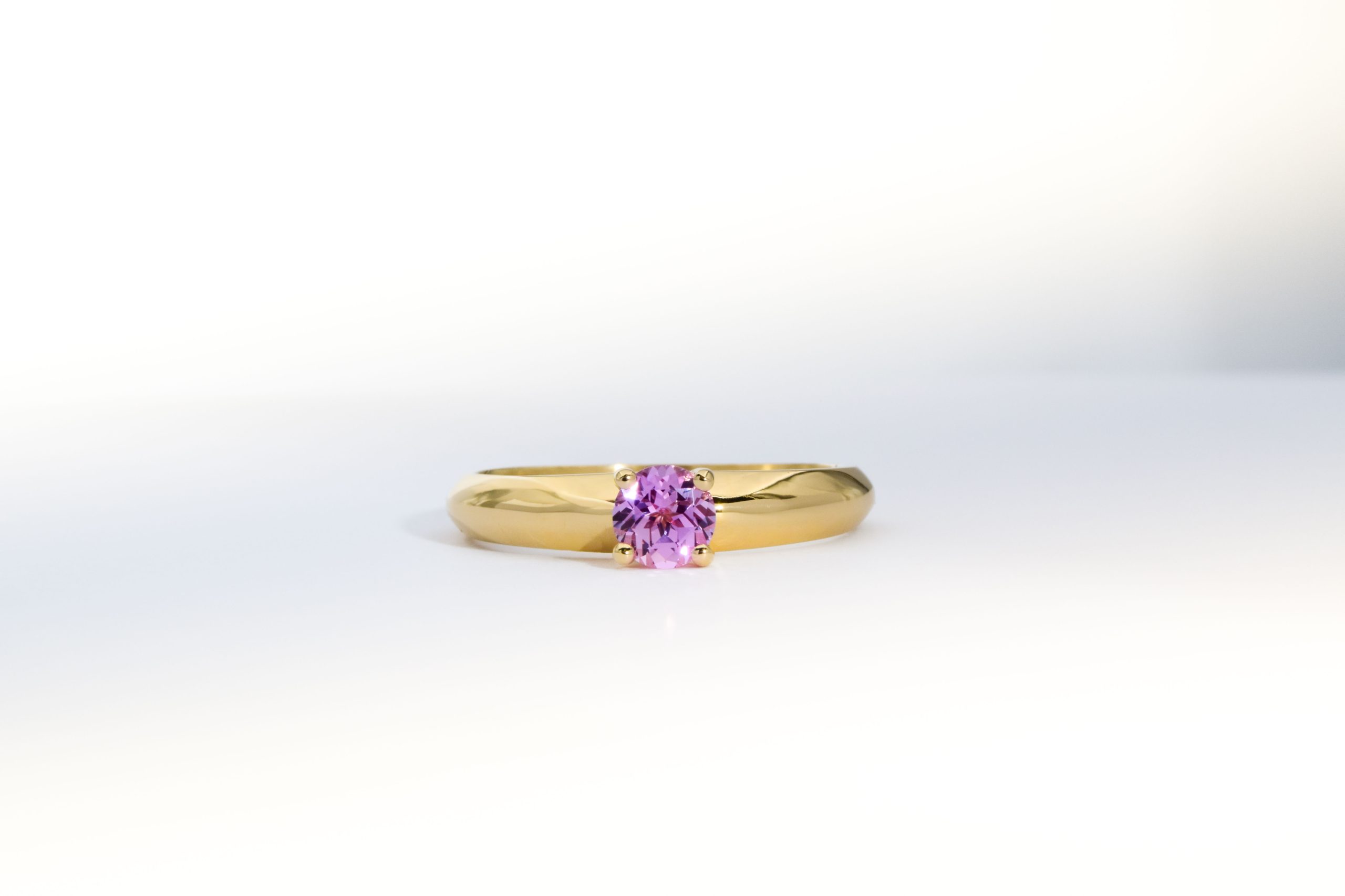 Anillo de compromiso de oro 18K amarillo modelo Princess 5 con zafiro Lab Grown Rosa sobre fondo blanco